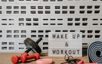 Fitness gear and motivational sign in home gym setup against a brick wall.